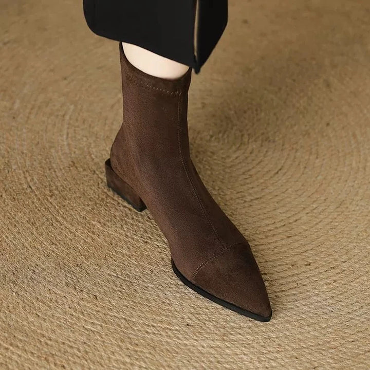 Närbild på texturerat material och söm på bruna damboots