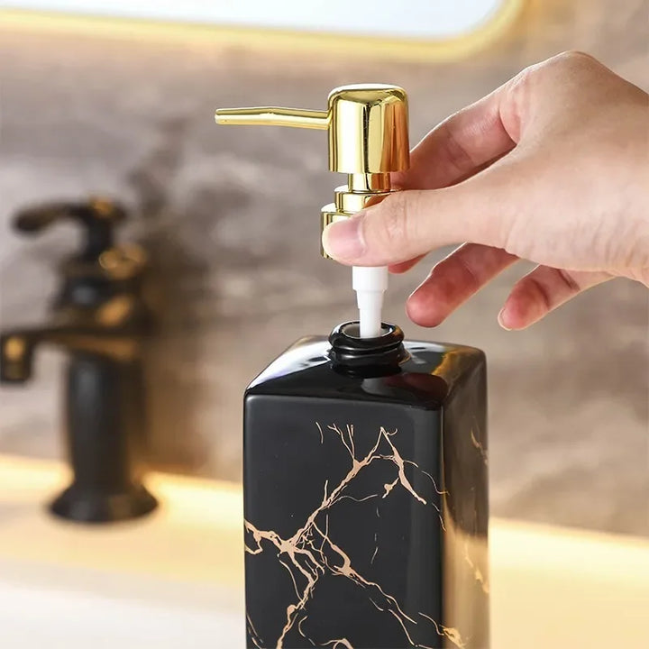 Närbild på tvåldispenser i keramik med elegant marmorering och pump