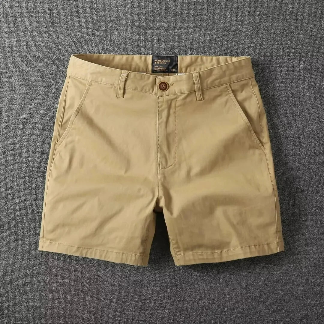 Närbild på knapp och gylf på beiga sommarshorts för herrar
