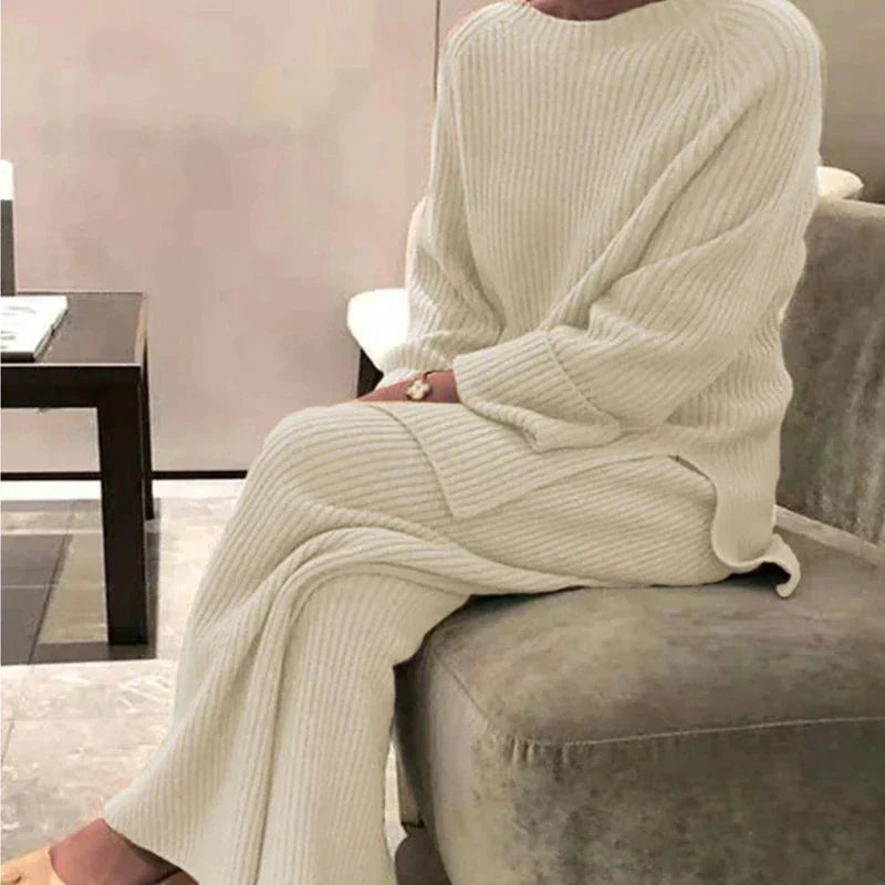 Dam i beige ribbad tröja och vida byxor för en mysig vinteroutfit.