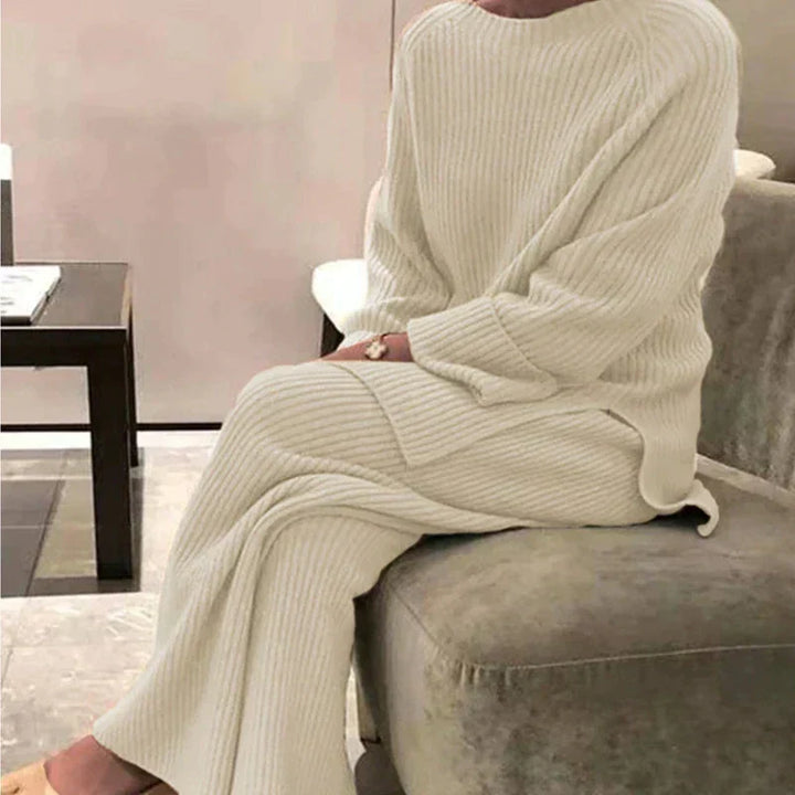 Dam i beige ribbad tröja och vida byxor för en mysig vinteroutfit.