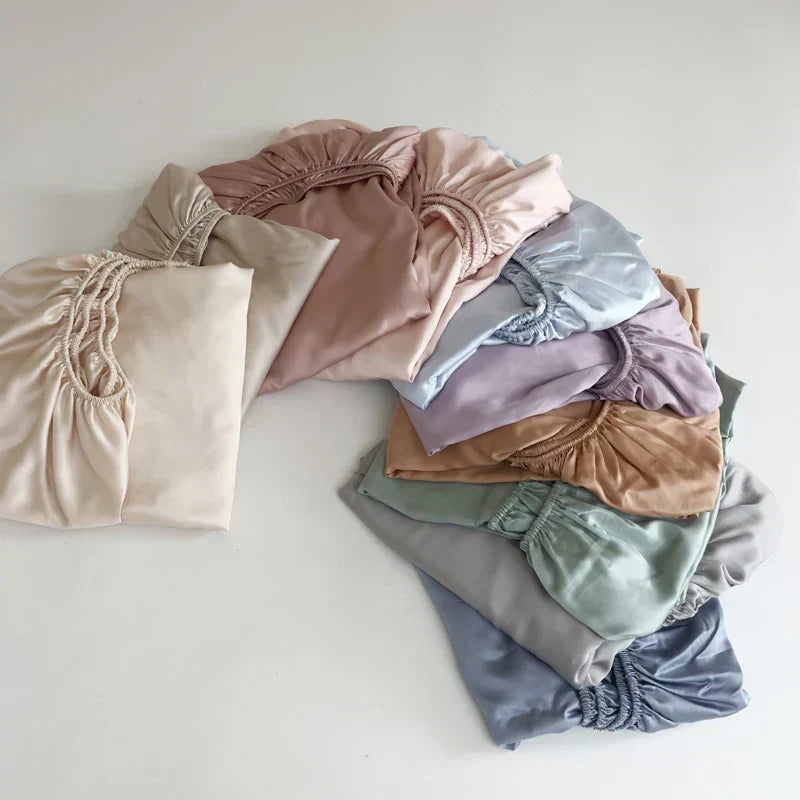 Vikta lyxiga sängkläder i silke staplade i elegant hemtextil