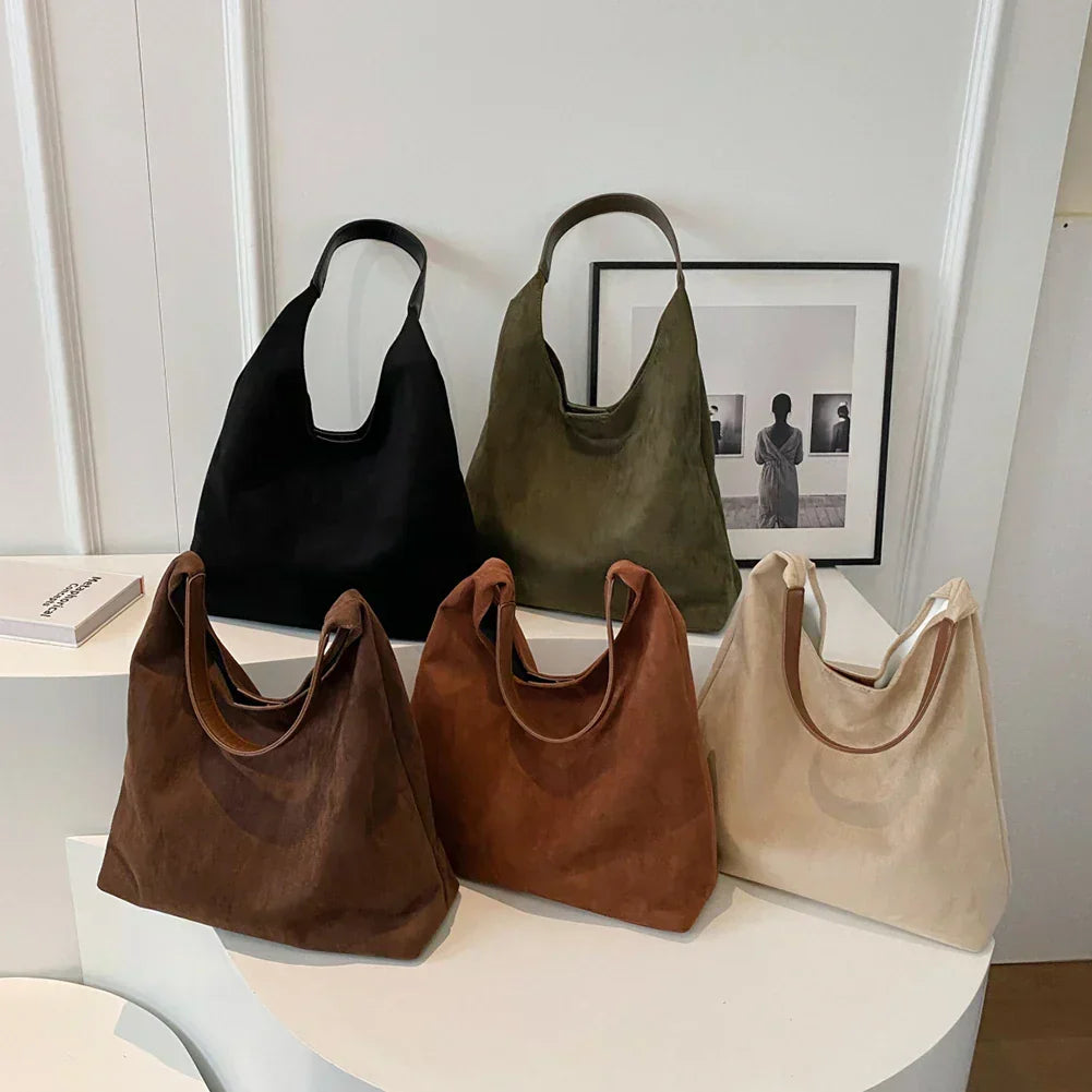 Fem olika färger av mjuk faux suede-axelväska uppställda tillsammans