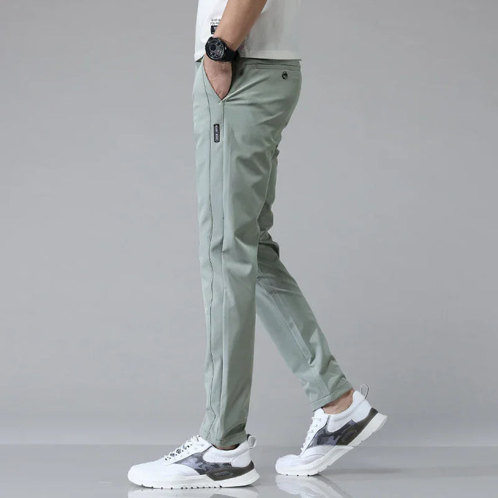 Man i ljusgröna ultralätta slim fit-byxor från sidan