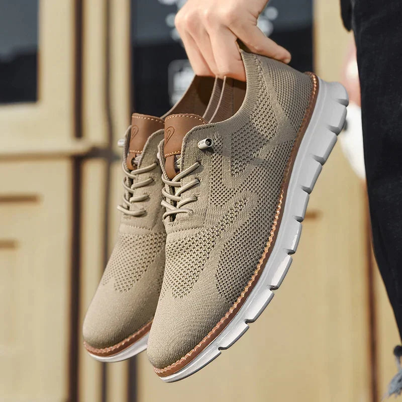 Khakifärgade lätta herrsneakers som hålls upp i handen