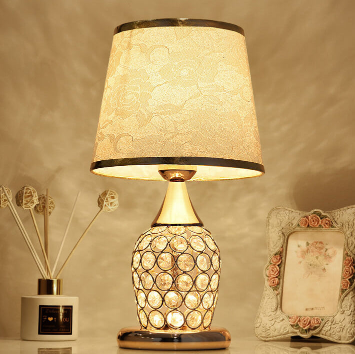 Elegant bordslampa i kristall med mönstrad skärm placerad på ett bord