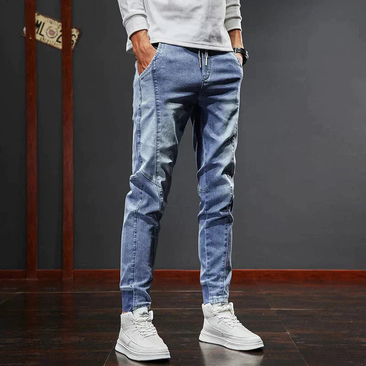 Man bär blå Mason slim fit jeans med vit tröja och vita sneakers