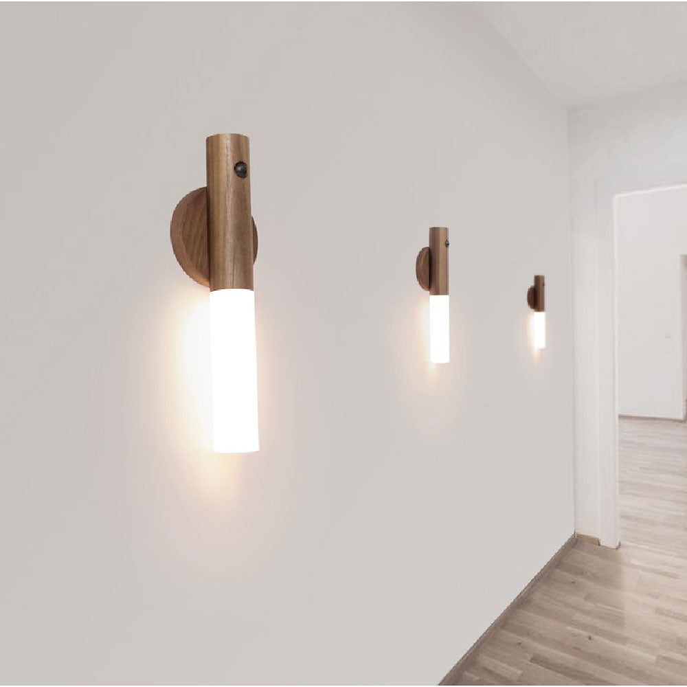 Trådlös LED-vägglampa med träfinish monterad på vit vägg