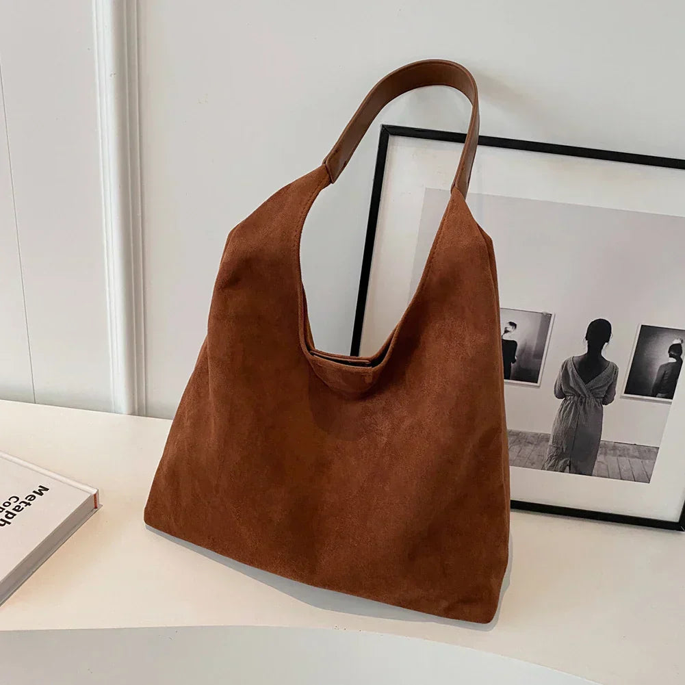 Brun damaxelväska i mjuk faux suede mot vit bakgrund