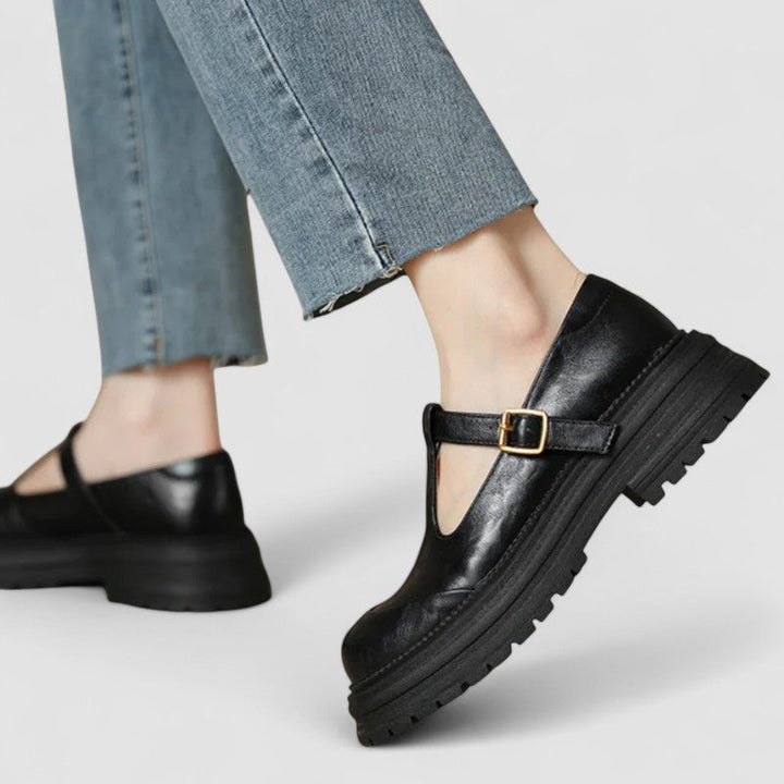 Svarta Mary Janes skor med grov sula på modell i jeans