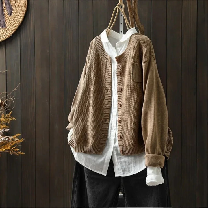 Närbild på textur och knäppning på beige ribbstickad cardigan