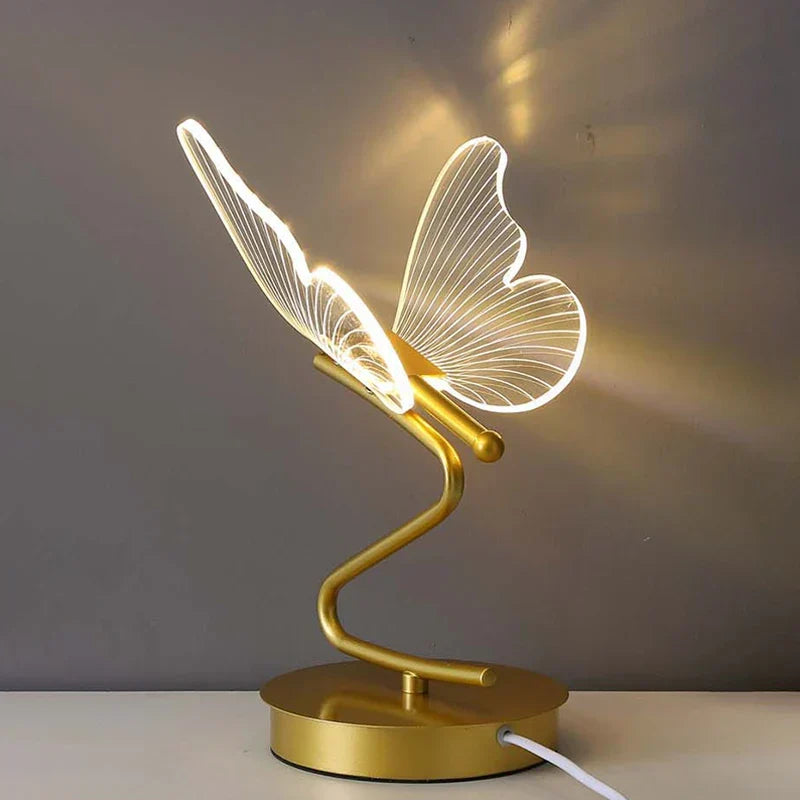 Guldfärgad LED-bordslampa Lunavia mot grå bakgrund