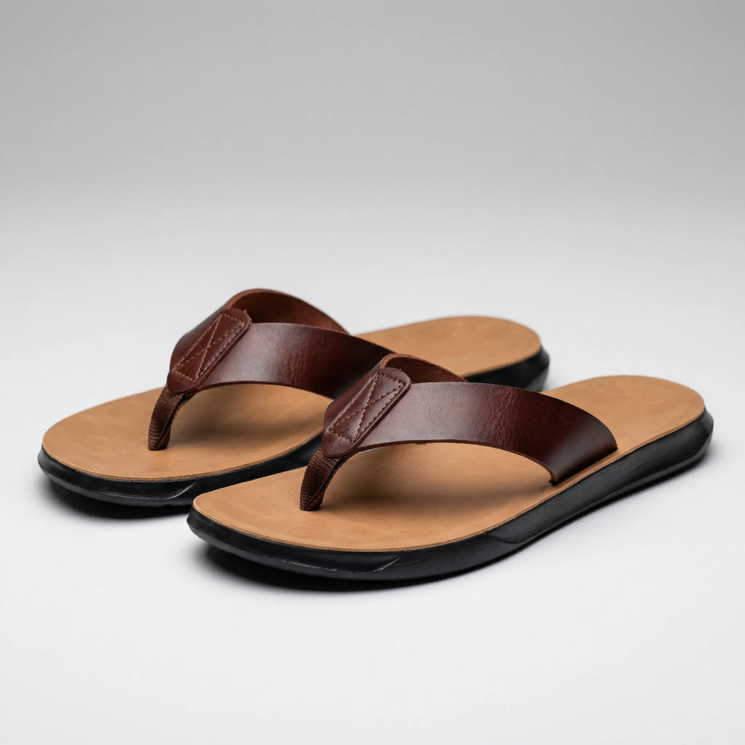Ett par bruna herrflip-flops uppställda på ljus bakgrund