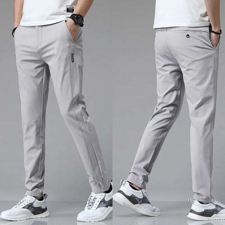 Man i ljusgrå ultralätta slim fit-byxor bakifrån och framifrån