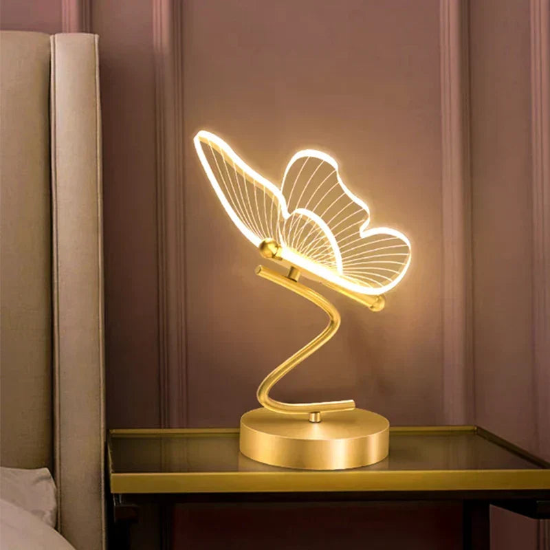 Bordslampa Lunavia med fjärilsdesign tänd på nattduksbord