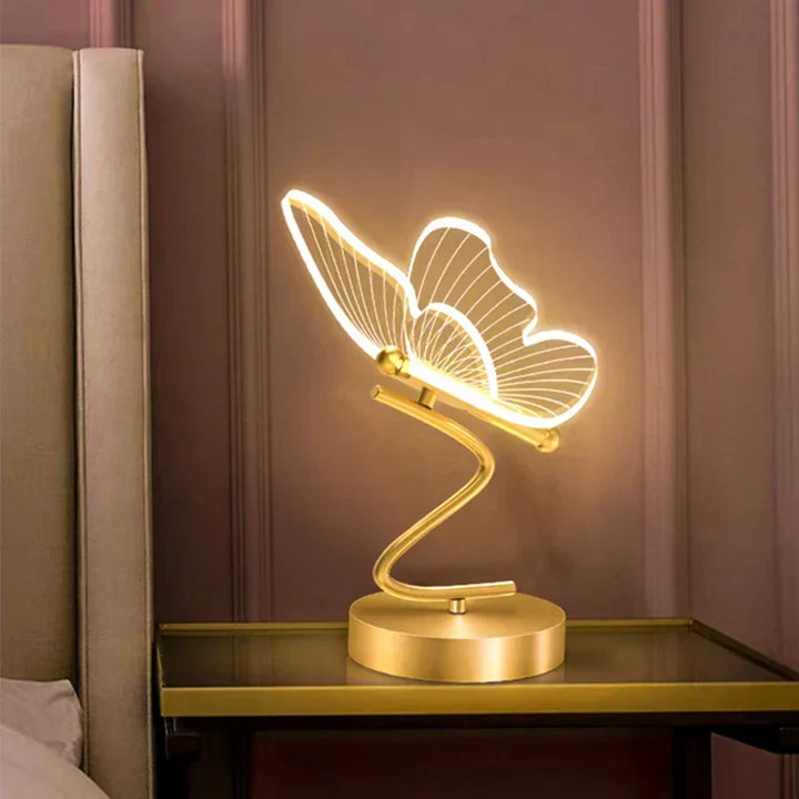 Bordslampa Lunavia med fjärilsdesign tänd på nattduksbord