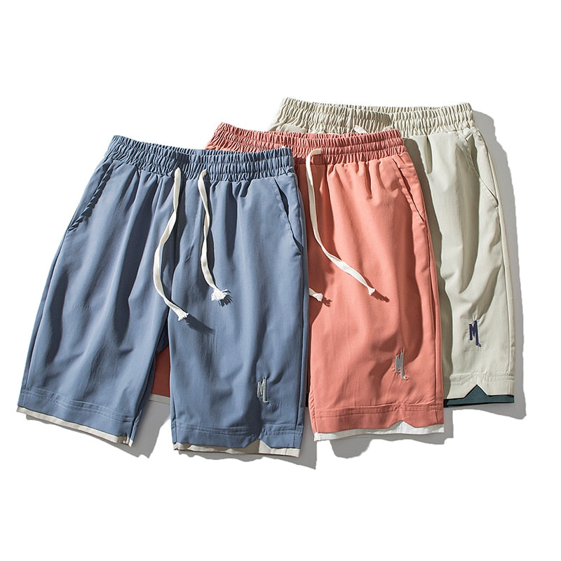 Tre par lätta herrshorts Dante i färgerna blå, rödorange och ljusgrå uppstaplade tillsammans