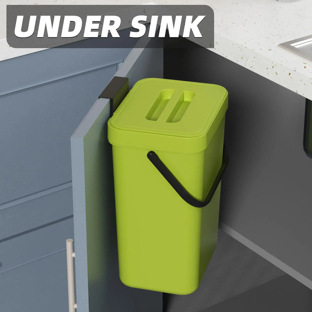 Grön mini soptunna hängande på skåpdörr under diskho i kök