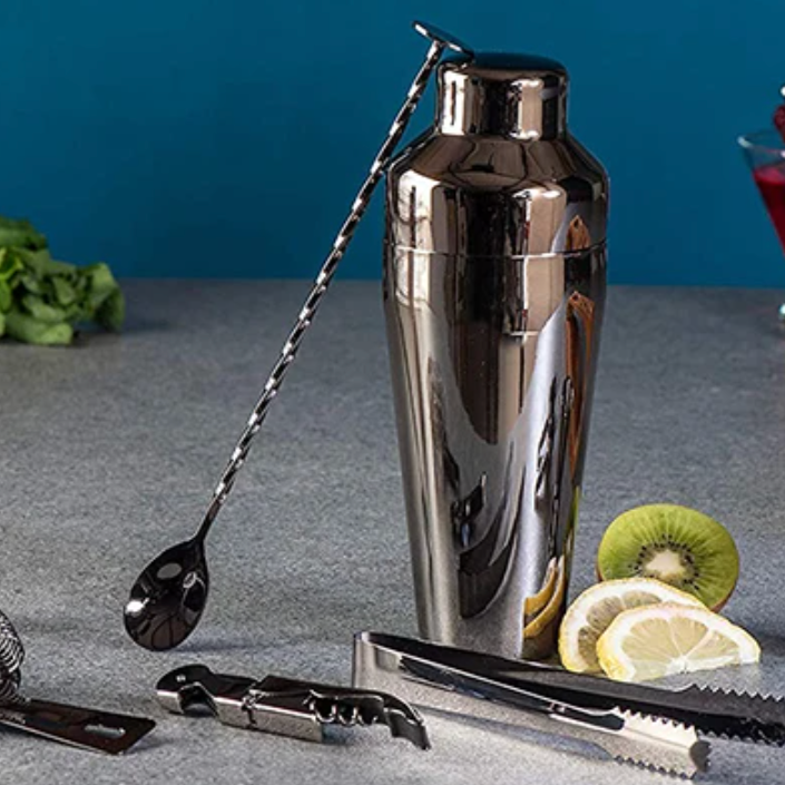 Närbild på cocktailshaker, barsked och istång i metall