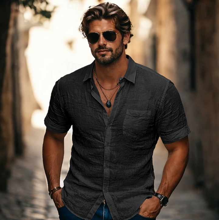 Man bär svart kortärmad skjorta med solglasögon