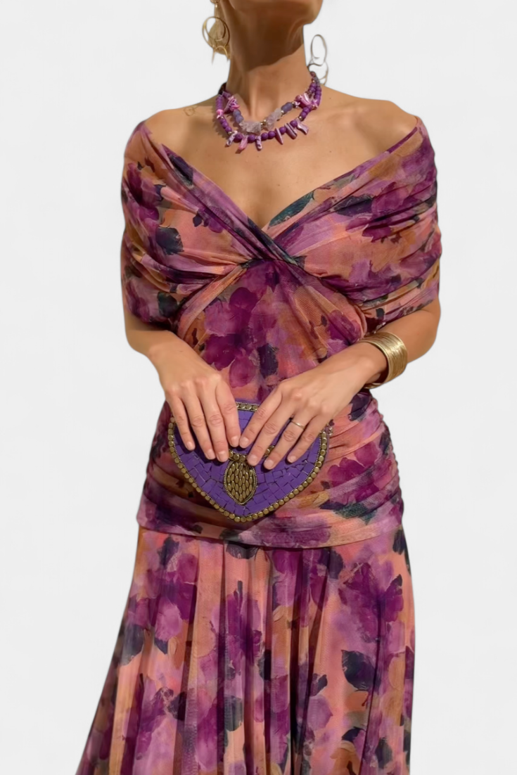 Kvinna i elegant blommig off-shoulder klänning framifrån med matchande accessoarer