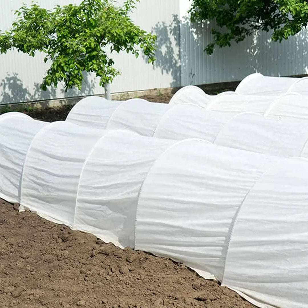 Trädgårdsbågar i glasfiber monterade över odlingsbädd som växttunnel