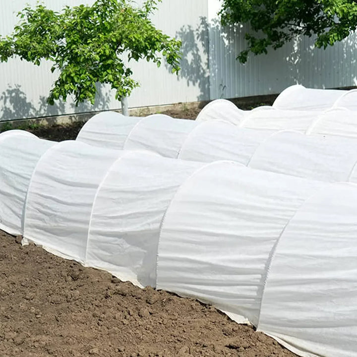 Trädgårdsbågar i glasfiber monterade över odlingsbädd som växttunnel