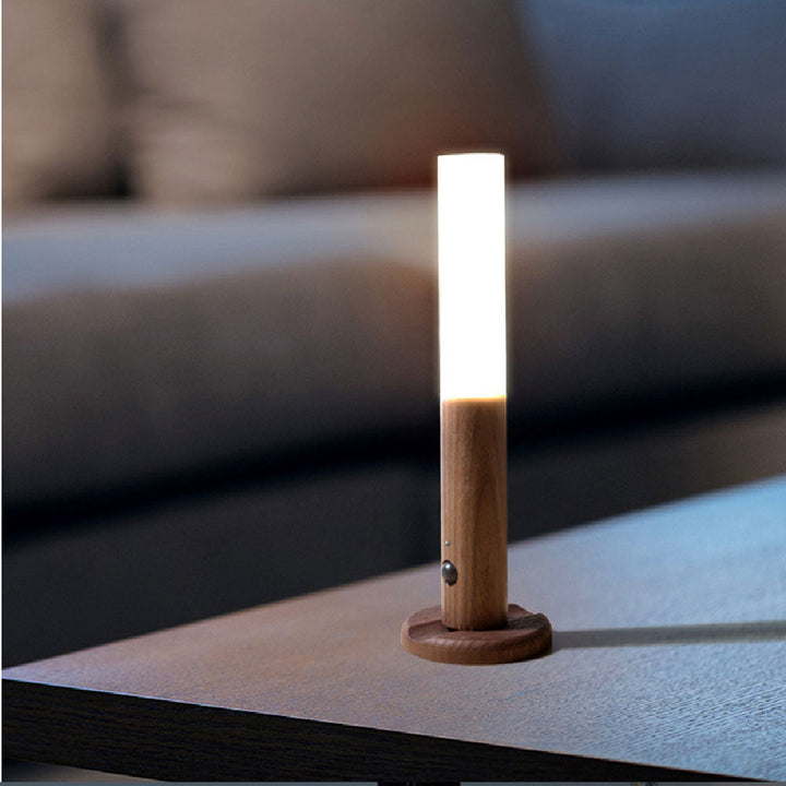 Portabel LED-vägglampa stående på bord med varmt ljus