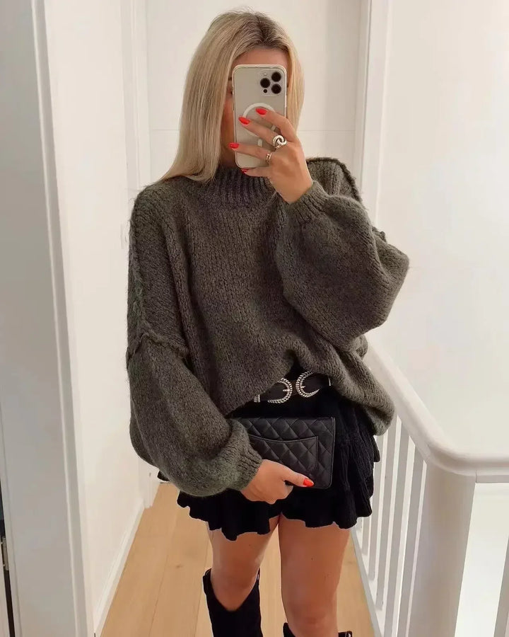 Kvinna i taupefärgad oversized stickad tröja med volymärmar