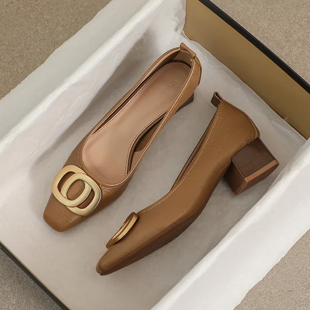 Par med eleganta beige pumps med guldemblem i skokartong med silkespapper
