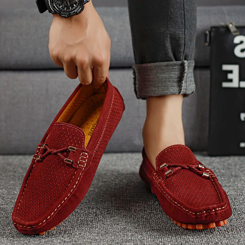 Röda loafers för män som hålls upp för att visa design och detaljer