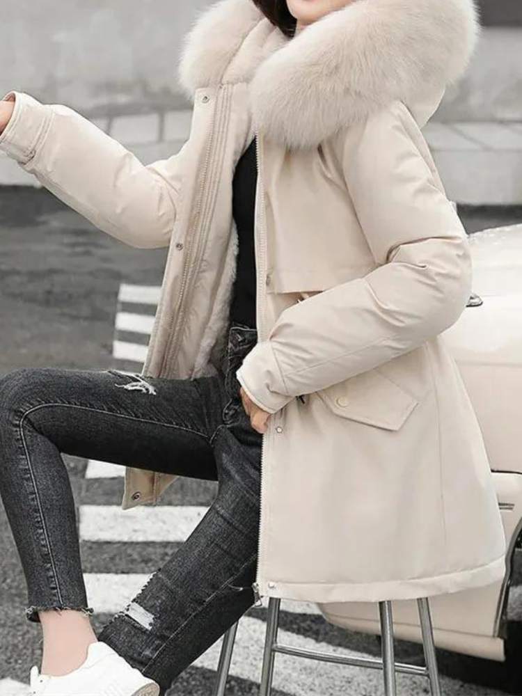 Kvinna som bär beige Sierra vinterjacka med pälskantad huva utomhus