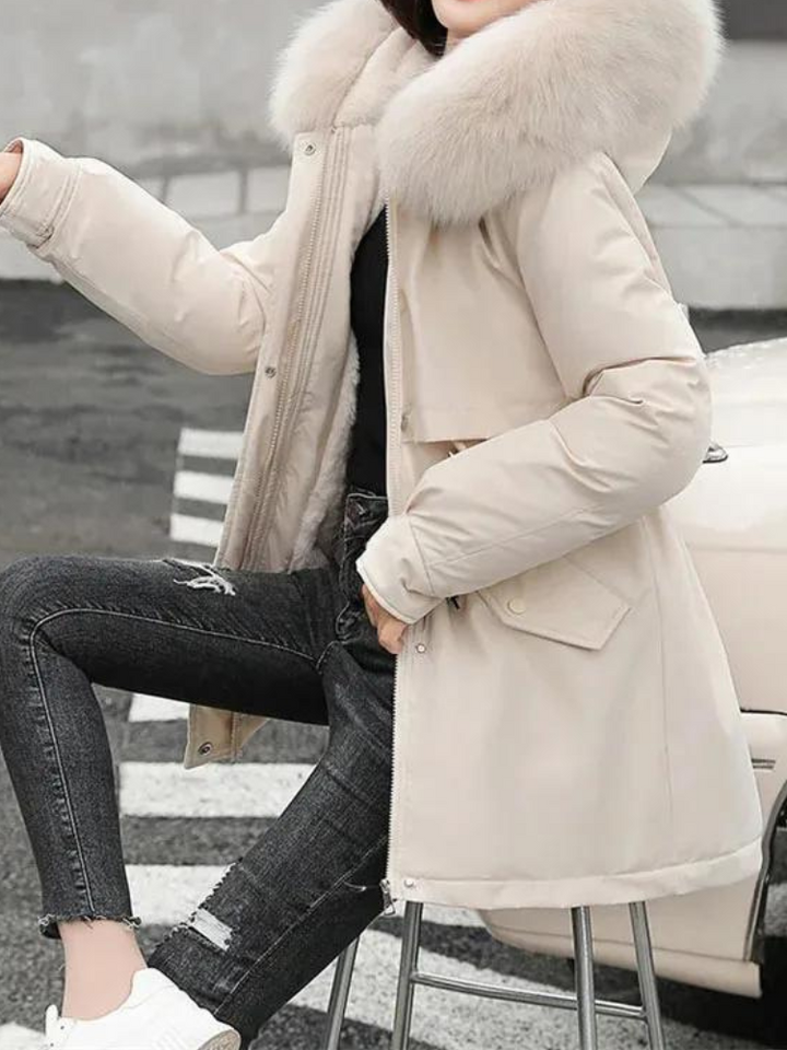 Kvinna som bär beige Sierra vinterjacka med pälskantad huva utomhus