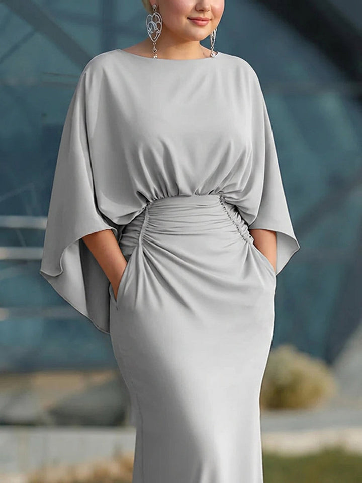 Närbild på midjan och ärmarna på den eleganta silverfärgade maxiklänningen