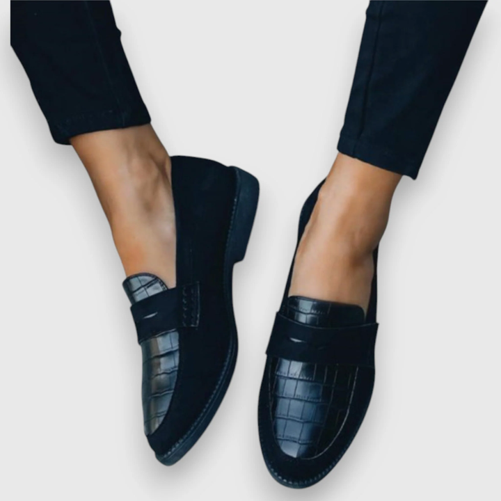 Svarta damloafers med crocomönster sedda framifrån på fötterna