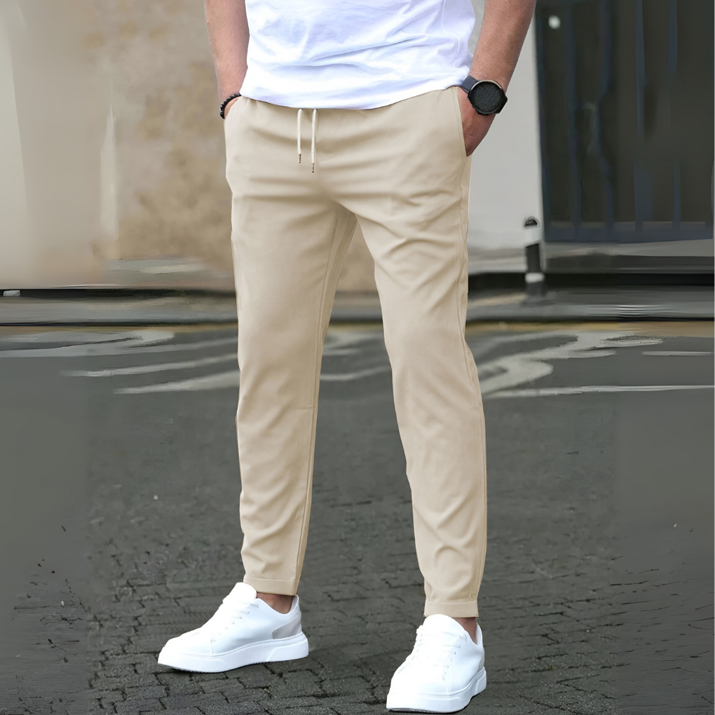 Man i beige slim fit byxor med vita sneakers