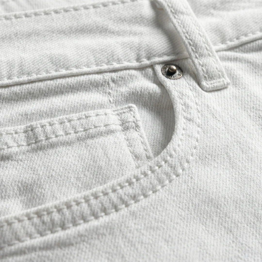 Närbild på fickdetaljer och sömmar på vita jeans