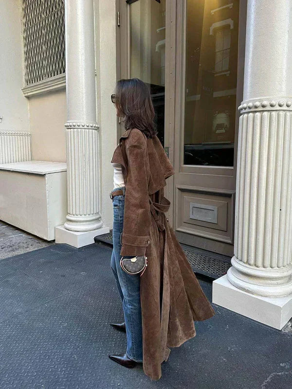 Sida av den eleganta bruna trenchcoaten med midjebälte