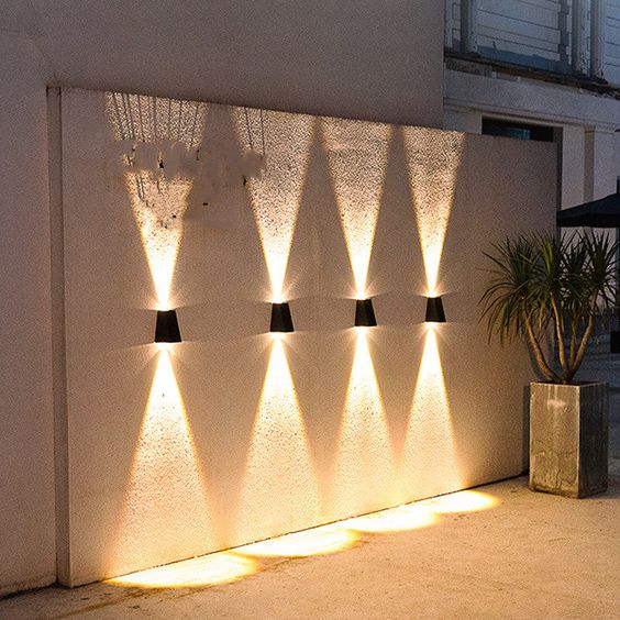 Solcellsvägglampa med dekorativt ljus på husfasad