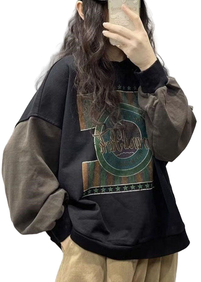 Person som bär svart streetwear-tröja med tryck