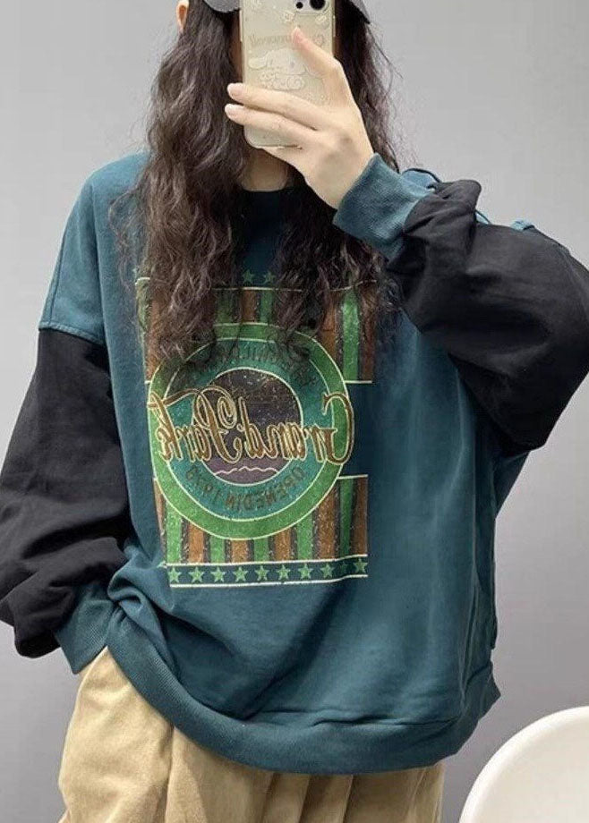 Person som bär grön streetwear-tröja med tryck
