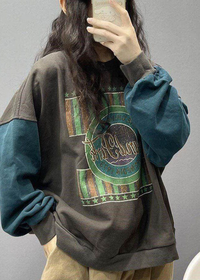 Person som bär mörkgrå streetwear-tröja med tryck