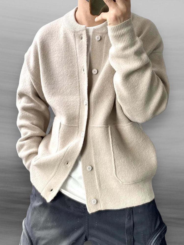 Närbild på beige stickad kofta med knappar och fickor