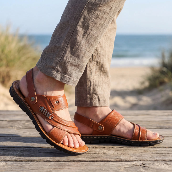 Herrsandaler med öppen tå i ljusbrun färg på strandpromenad