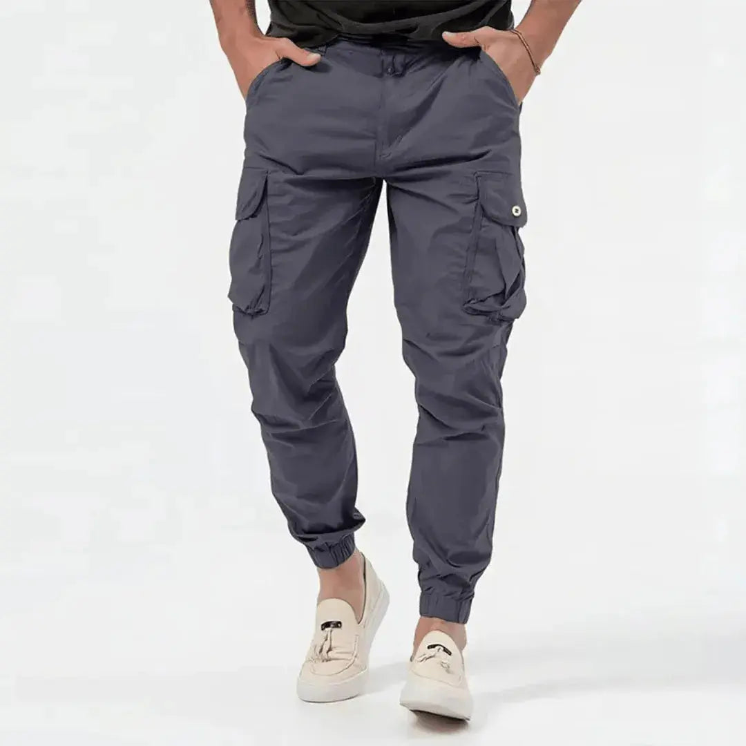 Helhetsbild bakifrån av mörkgrå stretchiga cargo joggers för en stilsäker herrgarderob.
