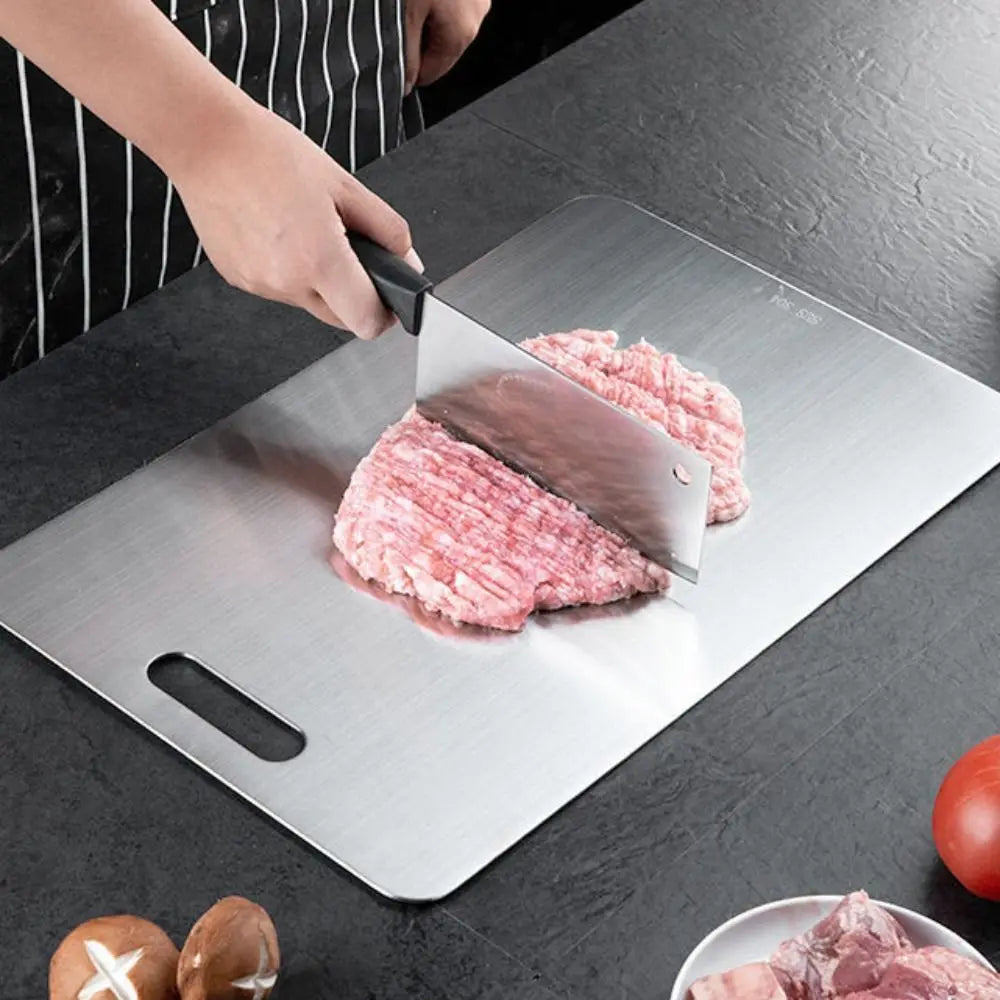 Person som skär kött på en robust skärbräda i titan i köket