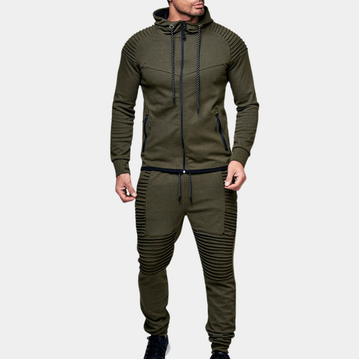 Man iklädd armégrön hooded tracksuit framför neutral bakgrund
