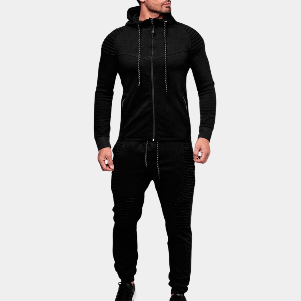 Man iklädd svart hooded tracksuit framför neutral bakgrund