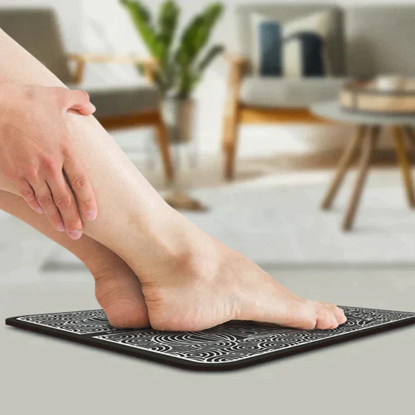 Kvinna som använder den bärbara fotmassageraren i ett ljust vardagsrum