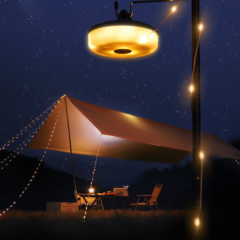 Campinglampa och ljussträng som lyser upp ett tält i mörkret